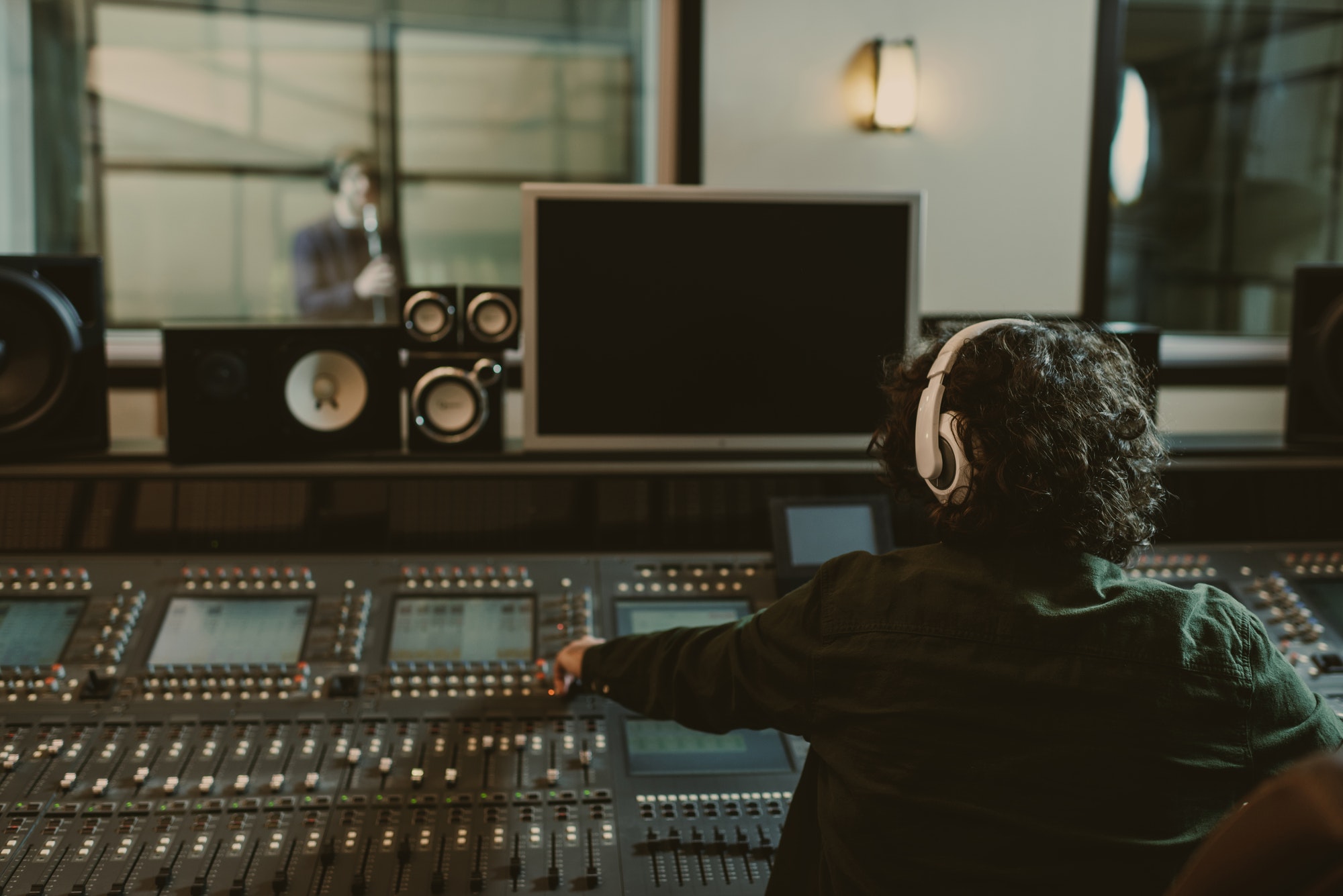 back-view-of-sound-producer-working-at-studio-while-recording-song.jpg